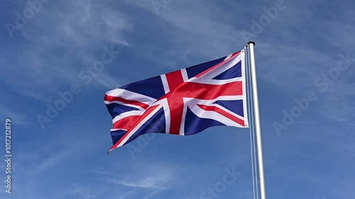 Slow motion, flag of Great Britain, United Kingdom fluttering in the wind against a blue sky