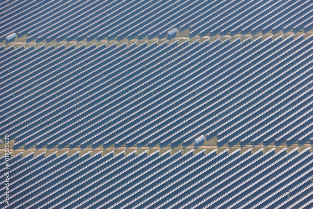 Obraz premium Aerial view of solar panels creating a textured pattern, symbolizing sustainability and innovation.