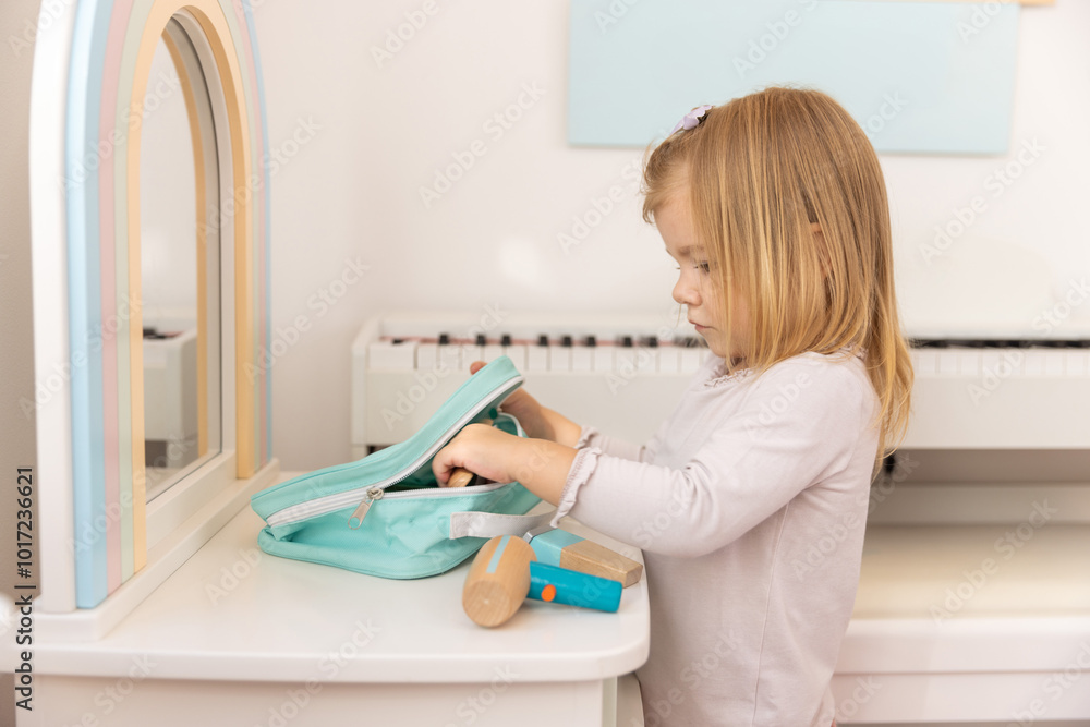 Little girl playing alone in the kindergarten with wooden toys Little girl playing alone in the kindergarten with wooden toys