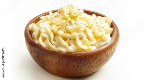 A close-up view of a bowl of creamy pasta, featuring a rich, velvety sauce on spiral-shaped noodles, served in a rustic wooden bowl, evoking comfort and satisfaction.