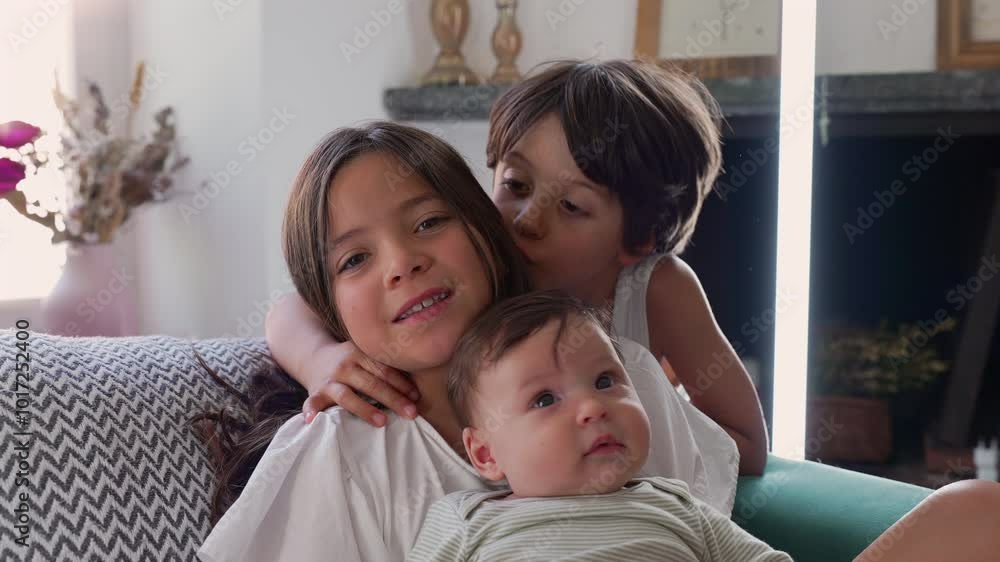 Older child kissing sister and baby on the cheek while the other child watches with a caring gaze, tenderness of sibling relationships in a comfortable home setting Older child kissing sister and baby on the cheek while the other child watches with a caring gaze, tenderness of sibling relationships in a comfortable home setting