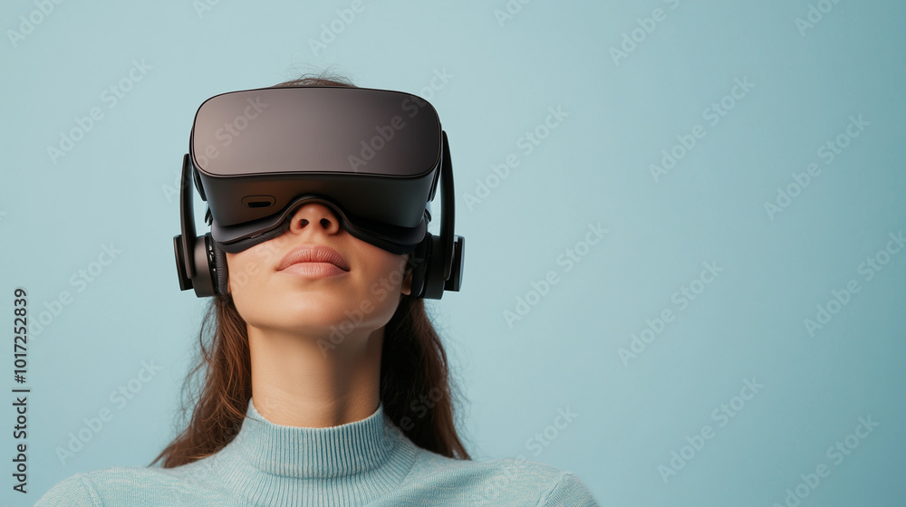 Immersed in virtual world, woman wears sleek VR headset against soft blue background, showcasing future of technology and gaming. Immersed in virtual world, woman wears sleek VR headset against soft blue background, showcasing future of technology and gaming.