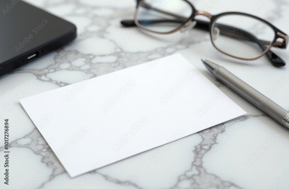A clean workspace featuring a blank card, pen, glasses, and a smartphone on a marble desk, ideal for writing notes or ideas A clean workspace featuring a blank card, pen, glasses, and a smartphone on a marble desk, ideal for writing notes or ideas