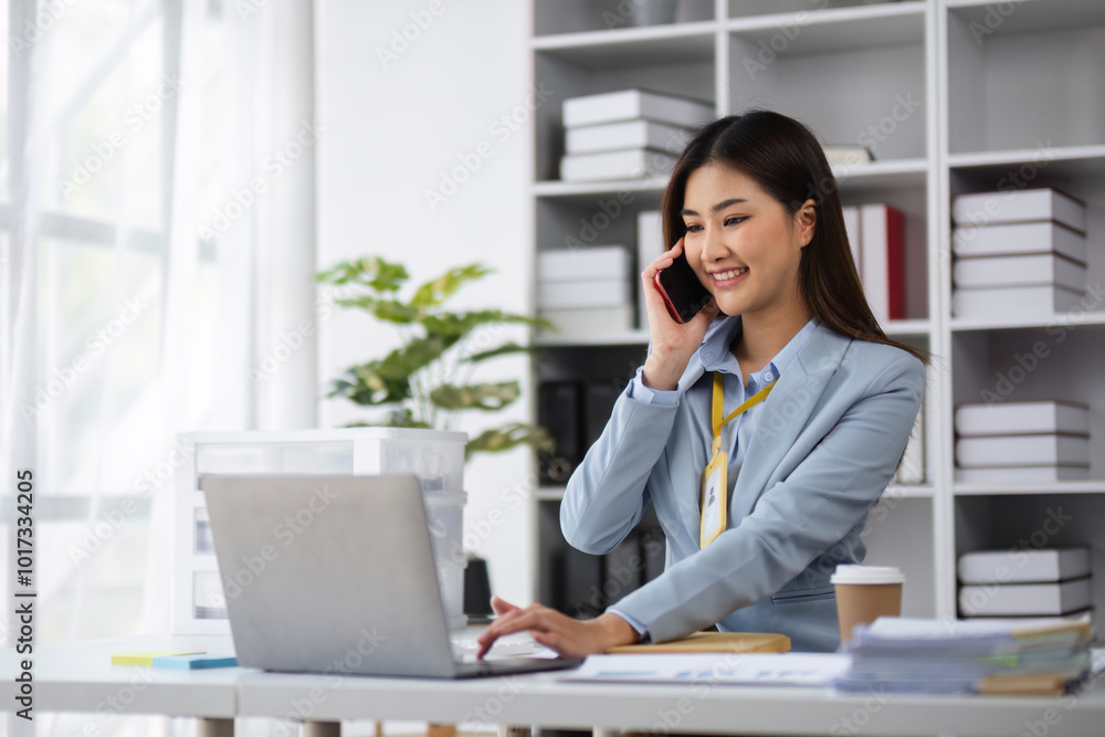 Professional Female Accountant Using Phone to Contact Customer in Modern Office Setting Professional Female Accountant Using Phone to Contact Customer in Modern Office Setting