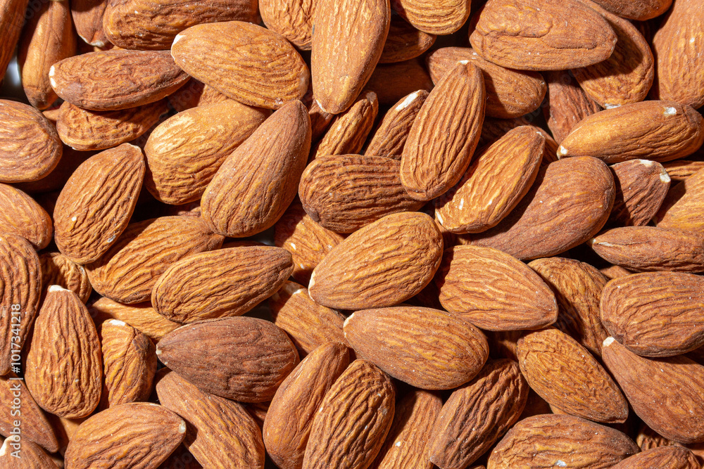 Fototapeta premium Scattered Almonds. Background from Almond Nuts. Natural High-Calorie Snacks
