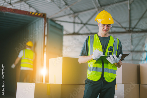 Three warehouse workers using a digital tablet while recording inventory. Logistics employees working with warehouse management software in a large distribution centre.