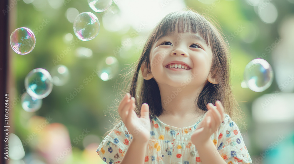 A young girl is standing in a field of bubbles, smiling and clapping her hands A young girl is standing in a field of bubbles, smiling and clapping her hands