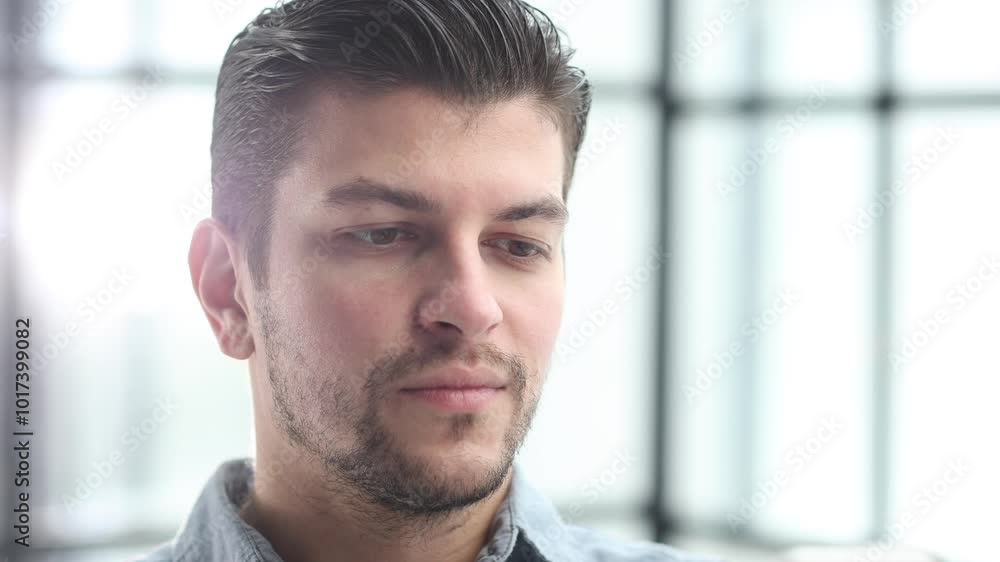 The man's face in close-up looks thoughtfully at the camera