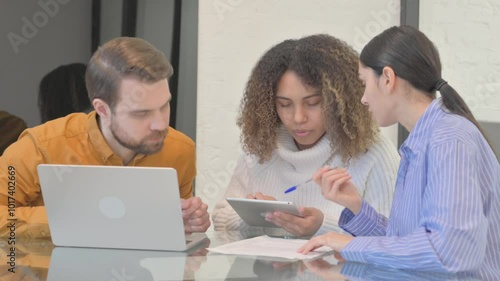Mixed Race Entrepreneurs Discussing Online Work in Office