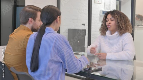 Young African Woman Giving Money to Couple and Shaking Hand