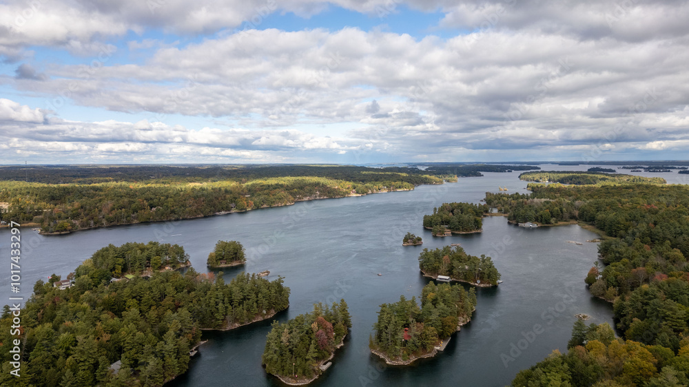 Obraz premium Stunning aerial views of the 1000 Islands region along the United States and Canada border, showcasing a mesmerizing landscape of lush green islands scattered across the blue waters of the St. Lawrenc