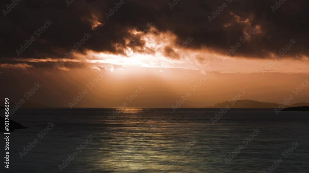 As the sun sets, the tranquil waters reflect the warm orange and red hues of the sky and distant islands. As the sun sets, the tranquil waters reflect the warm orange and red hues of the sky and distant islands.
