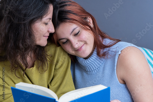 Mother and daughter enjoying reading a book together in a cozy connection.