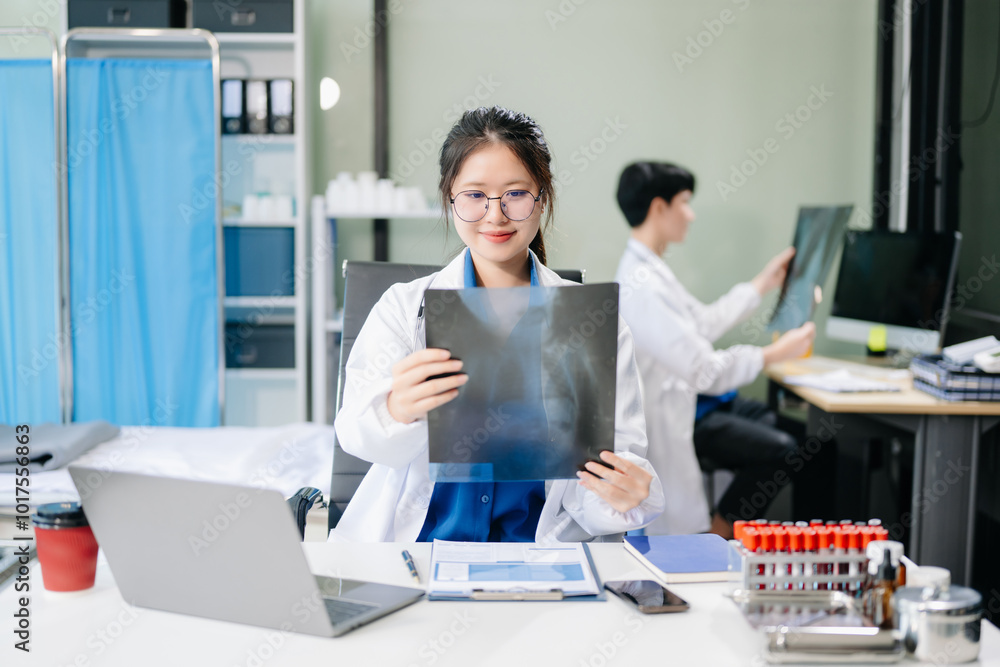 Confident young asian female doctor in white medical uniform sit at desk working on computer. Confident young asian female doctor in white medical uniform sit at desk working on computer.