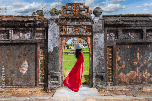 Asian woman in ao dai dress visits the Royal Palace of the Nguyen Dynasty in Hue, Vietnam.