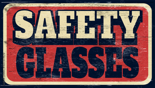Aged and worn safety glasses sign on wood