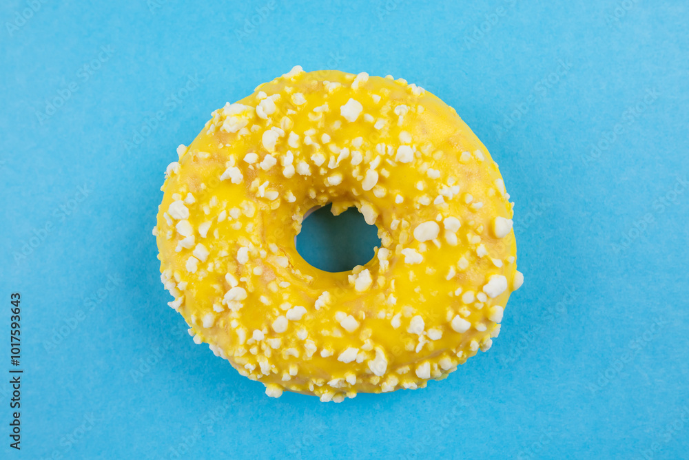 Yellow donut with icing on blue background, close-up, top view. Yellow donut with icing on blue background, close-up, top view.