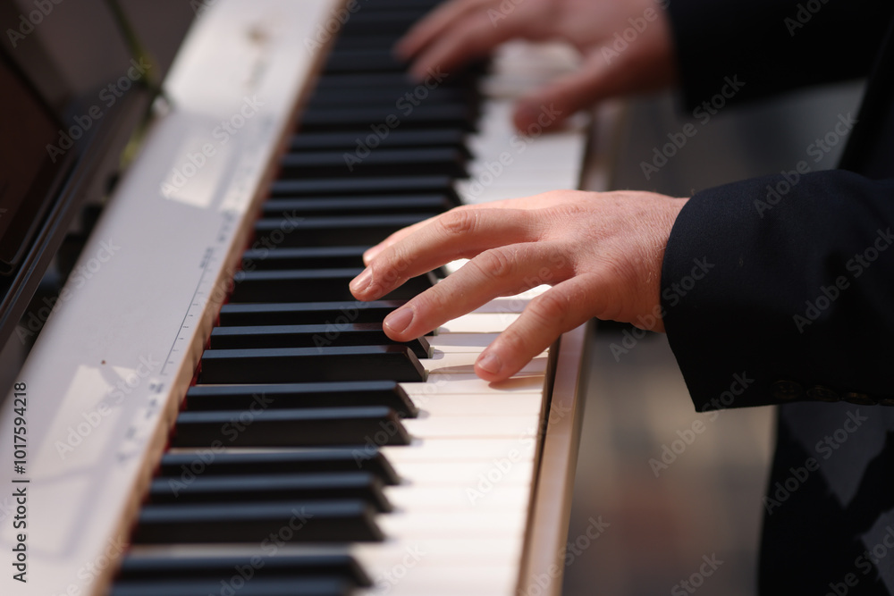 Details with the hands of a man playing an electric piano Details with the hands of a man playing an electric piano
