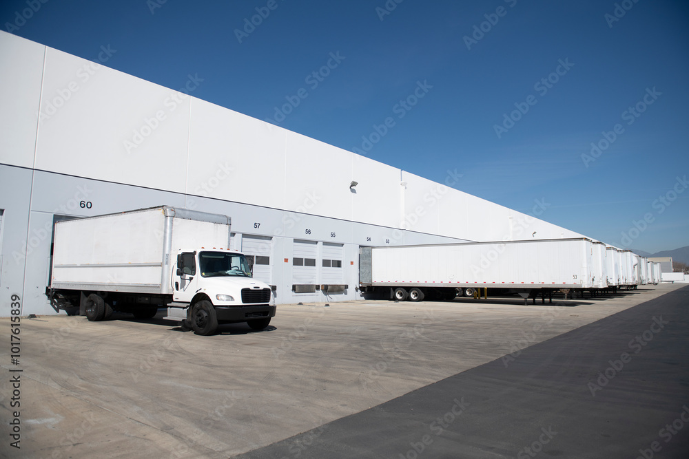 White box truck trailer parked at distribution warehouse bay White box truck trailer parked at distribution warehouse bay