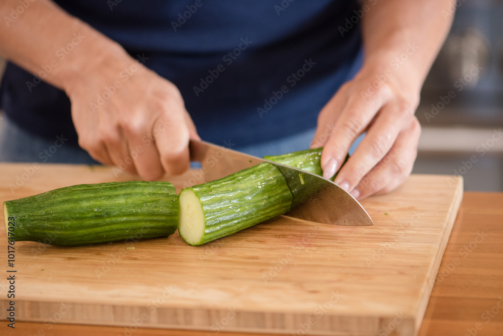 Close up of a womans hands chopping a cucumber Close up of a womans hands chopping a cucumber