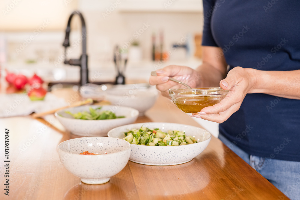 Woman holding vinegar over salad Woman holding vinegar over salad