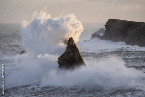 Large winter waves crash overy rocky coast, Playa de la Arnia, Spain photo