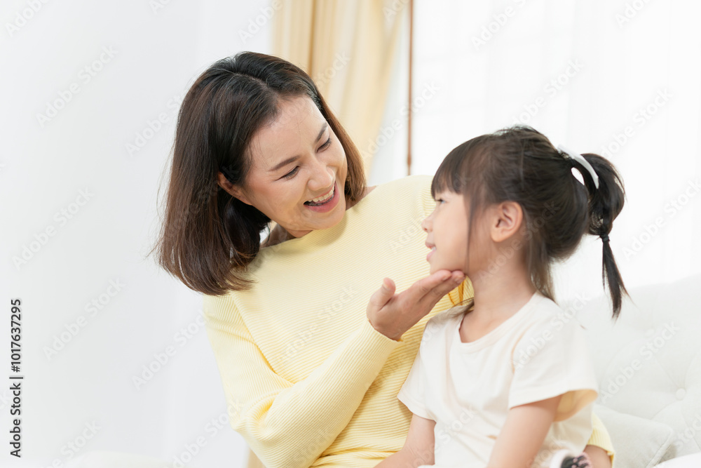 Asian mother enjoying with daughter in living room at home Asian mother enjoying with daughter in living room at home