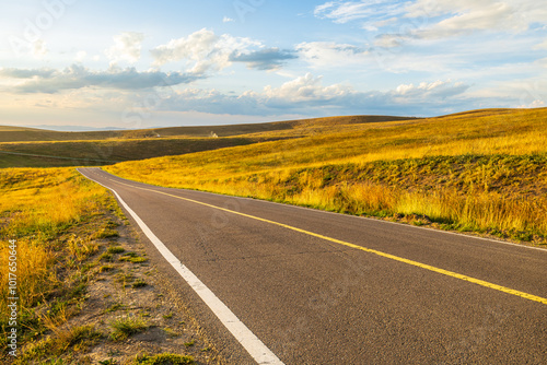 Asphalt road highway and beautiful grassland with mountain nature landscape in autumn. Road trip.