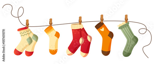 Beautiful different socks hang on a rope, secured with a clothespin. Washing, washed socks dry on a rope. Autumn and winter warm, woolen, knitted socks on a white background. An item of clothing.