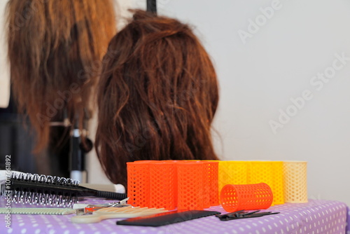 Colorful hair rollers and two mannequin heads for hair styling
