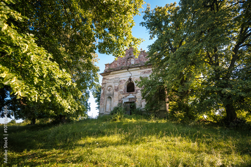 Ancient abandoned catholic church of 19th century in a linden grove. Ancient abandoned catholic church of 19th century in a linden grove.