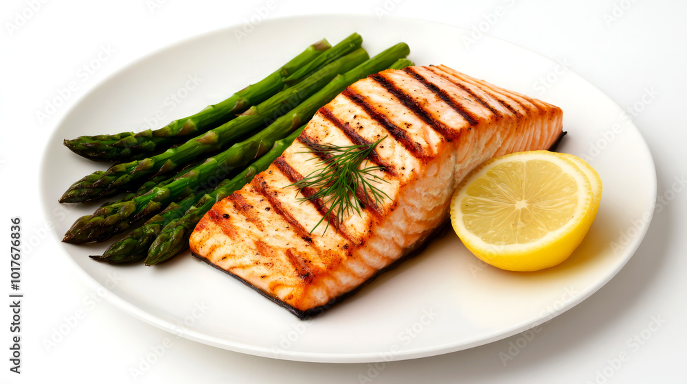 Grilled salmon fillet served with asparagus and lemon on a white plate. Grilled salmon fillet served with asparagus and lemon on a white plate.