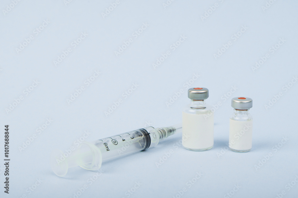 Top view Vaccine bottle with syringe isolated on blue bright backround and copy space Top view Vaccine bottle with syringe isolated on blue bright backround and copy space