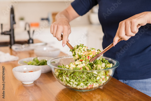 Mixing fruit salad with wood spoons photo