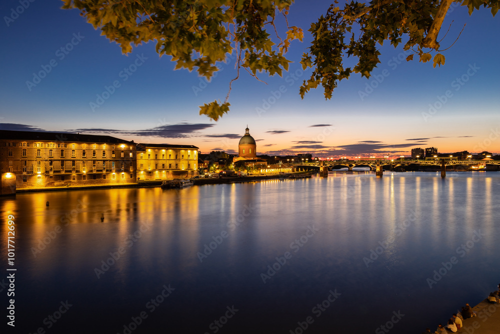 Obraz premium Golden sunset over Garonne river with views on the the pedestrian Saint-Pierre bridge, Place Saint-Pierre and the Grave hospital seen from the riverside 