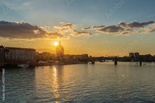 Golden sunset over Garonne river with views on the the pedestrian Saint-Pierre bridge, Place Saint-Pierre and the Grave hospital seen from the riverside  photo