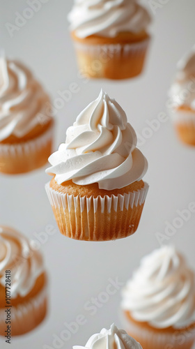 A floating cupcake with white frosting, surrounded by other cupcakes. The cupcakes have a golden-brown base and are topped with swirls of creamy frosting. photo