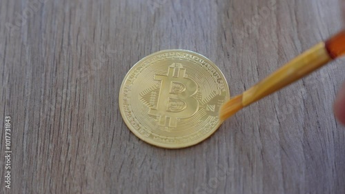 close-up shot of a person cleaning their golden bitcoin on a table photo