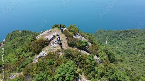 바다를 내려다보는 푸른 산 정상의 등산객들