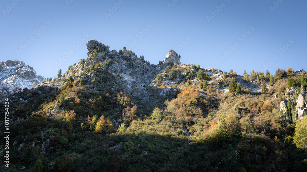 Beautiful autumn day in the french alps with colored trees and snowy moutains. Sunny day, blue sky Beautiful autumn day in the french alps with colored trees and snowy moutains. Sunny day, blue sky