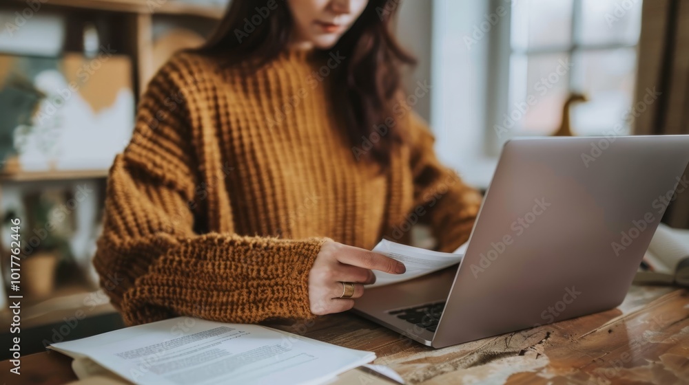 Captivating CloseUp Hands of a Business Professional in Brown Sweater Holding Document at Wooden Desk with Laptop Focus on Productivity and DetailOriented Work Environment Captivating CloseUp Hands of a Business Professional in Brown Sweater Holding Document at Wooden Desk with Laptop Focus on Productivity and DetailOriented Work Environment