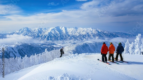 Snowboarders looking over the expansive Tokachidake mountain range from the heights of Furano ski resort, enjoying a clear, sunny day in Japanaes winter wonderland.