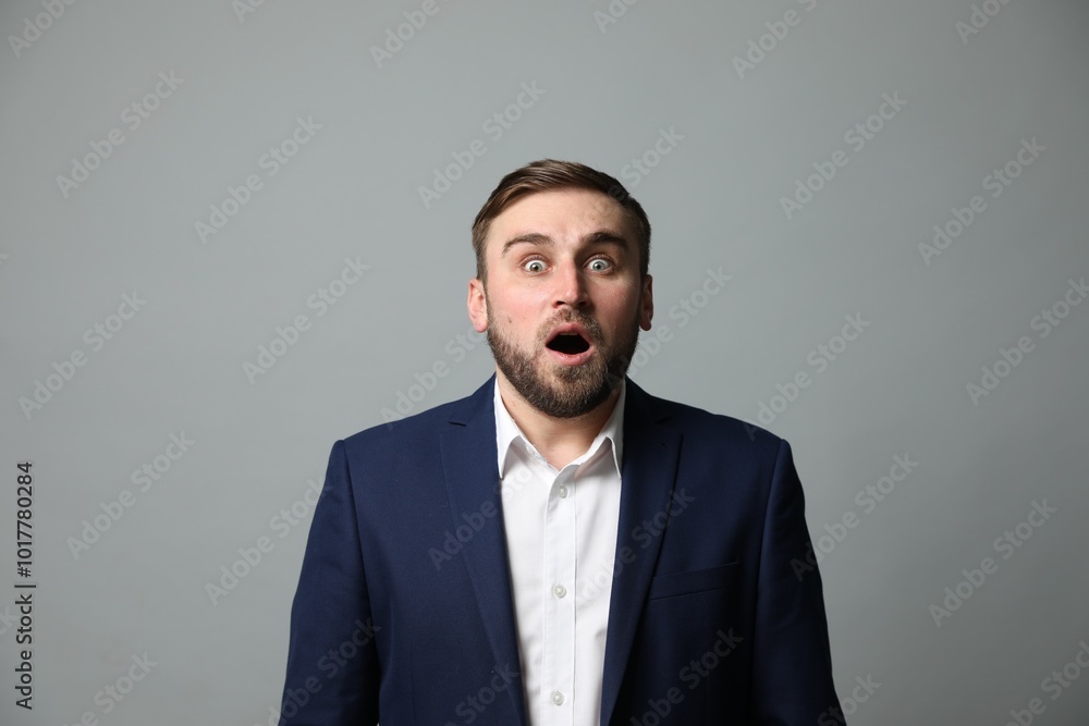 Young businessman feeling fear on grey background Young businessman feeling fear on grey background