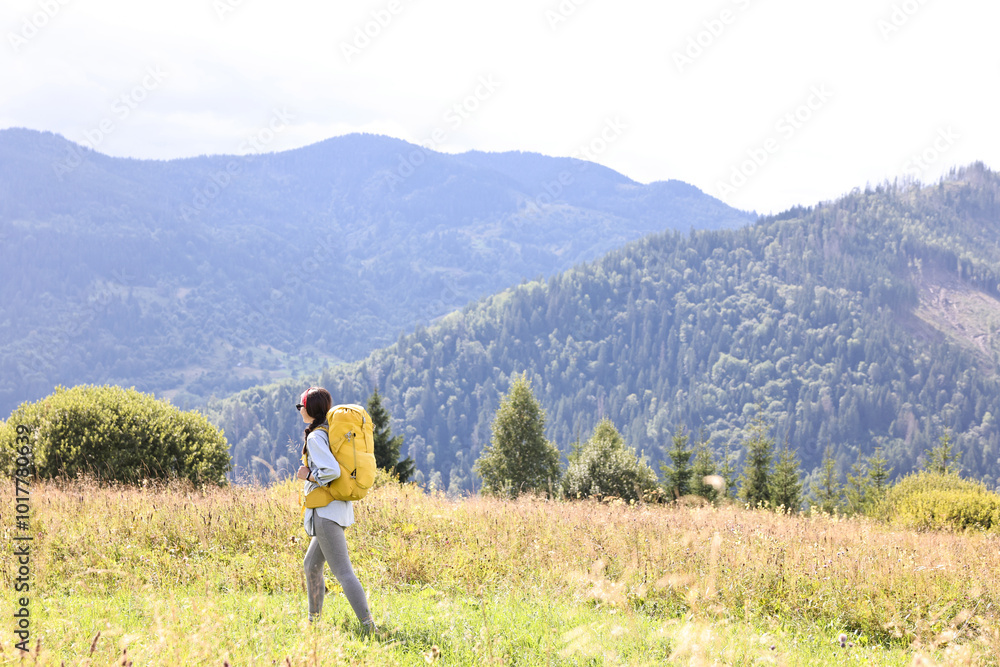 Young woman with backpack hiking in mountains Young woman with backpack hiking in mountains