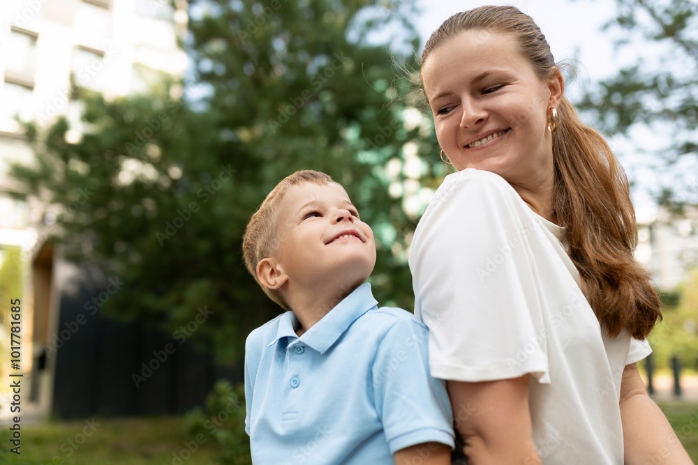 A joyful moment shared between a mother and her son in a sunny urban park during a warm afternoon A joyful moment shared between a mother and her son in a sunny urban park during a warm afternoon
