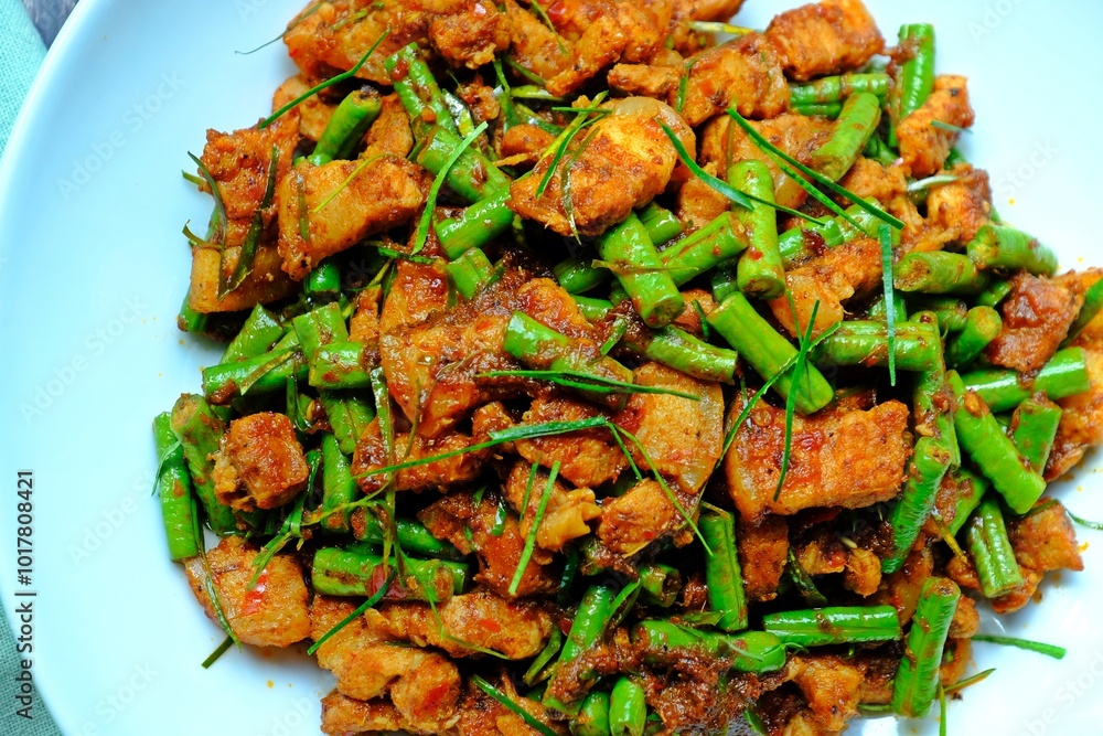 Stir fried crispy pork belly and yard long bean with ginger red curry paste, Authentic Thai food.
