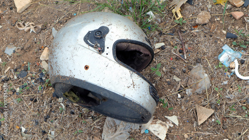 Wallpaper Mural An abandoned old motorcycle helmet rests on the ground, surrounded by debris in an unkempt area under natural light Torontodigital.ca