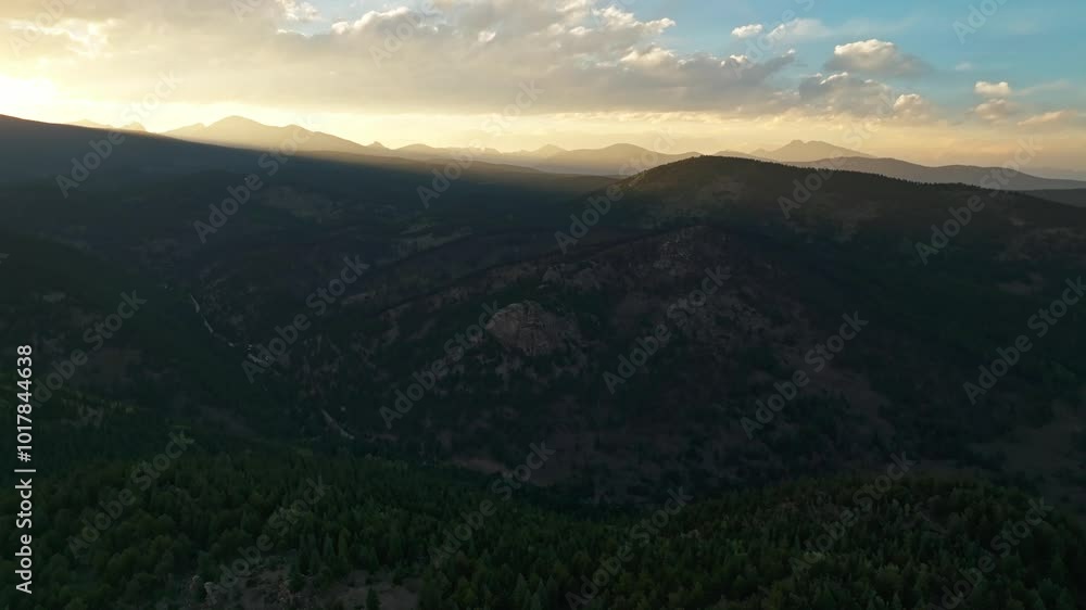 Aerial of a forested landscape with distant mountains in the background under a partly cloudy sky, Boulder Colorado Aerial of a forested landscape with distant mountains in the background under a partly cloudy sky, Boulder Colorado