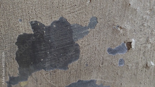  A close-up view of a weathered concrete wall showing peeled paint and surface imperfections. The worn texture and cracked surface provide a natural, rugged aesthetic suitable for background