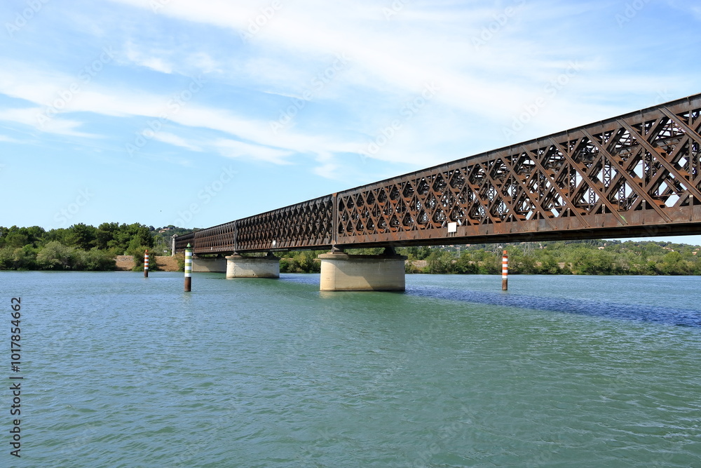 Obraz premium Beautiful Old Iron railway bridge Pont ferroviaire dit viaduc d'Avignon over the sparkling waters of the Rhone River near Avignon, France